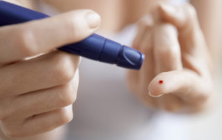 Woman Performing Blood Test on Herself